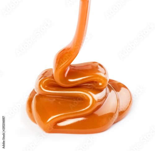 Pouring sweet caramel sauce on white background