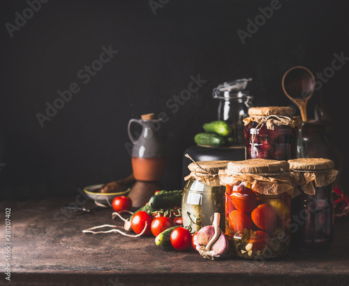 Fototapeta Naklejka Na Ścianę i Meble -  Vegetables and fruits canning. Various preserve glass jars on dark table. Homemade harvest storage. Copy space. Healthy food.