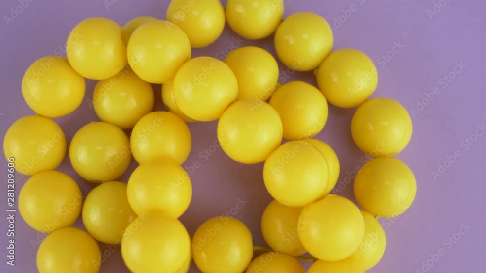 Yellow beads necklaces on violet or purple background for female person Yellow beads necklaces on violet or purple background for female person