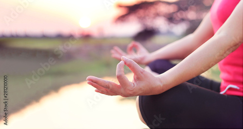 Woman practices yoga and meditates on the nature sunset background.
