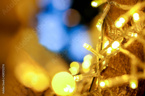 Closeup of Christmas lights and refection lighting on the tree with colorful blurred and bokeh and black background.