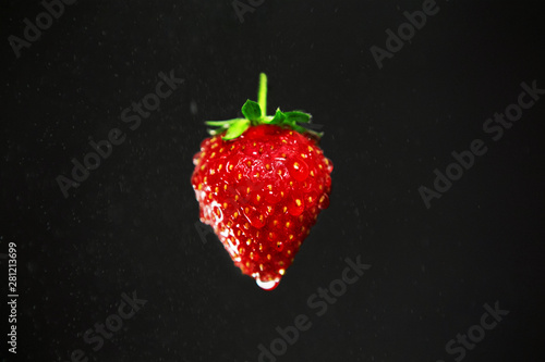Strawberry with water drops on black background.