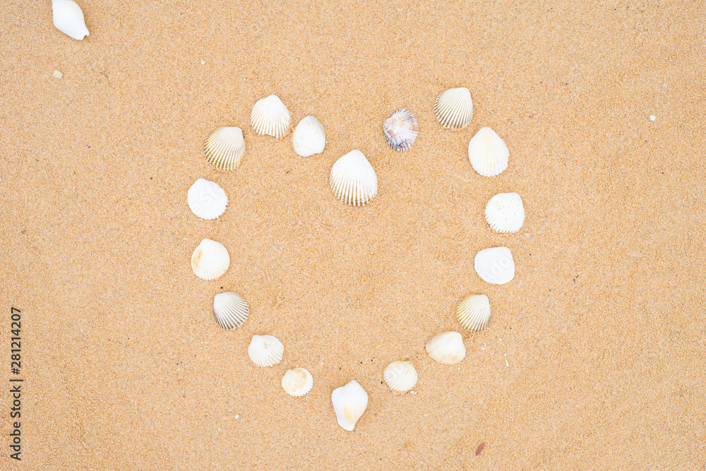 small seashells in the shape of a heart on a smooth sandy beach. small seashells in the shape of a heart on a smooth sandy beach.