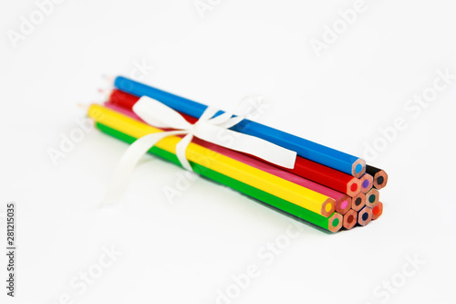 multicolored wooden pencils for drawing with white bow on a white background