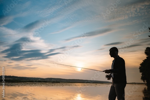 Fishing. spinning at sunset. Silhouette of a fisherman