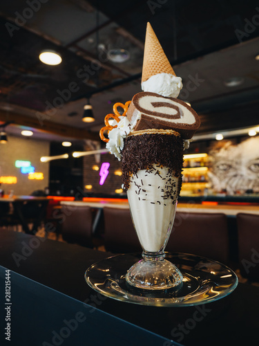 Chocolate freak shake with ice cream, brezel, cake and whipped cream photo