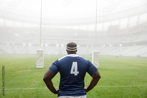 African american male rugby player standing with hands on hip in stadium