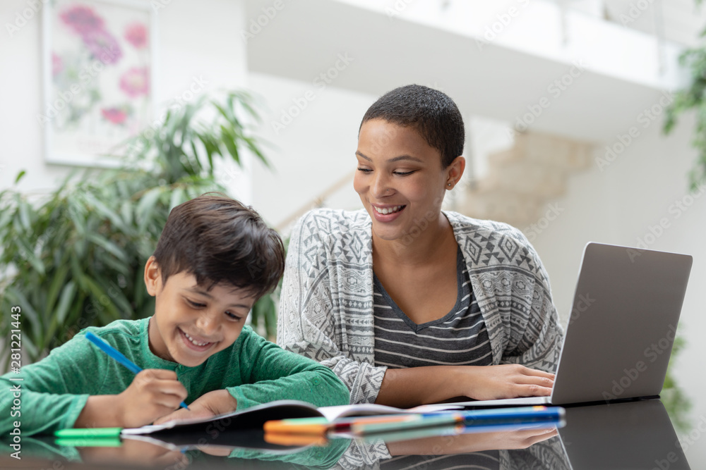 Mother helping his son with his homework on a table Mother helping his son with his homework on a table
