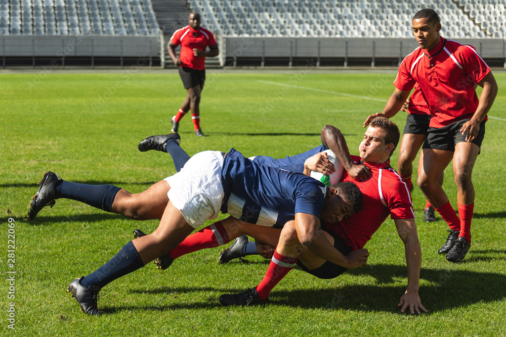 Obraz premium Male rugby players playing rugby match in stadium