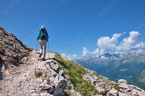 Fototapeta Naklejka Na Ścianę i Meble -  Low angle view of mature woman hiking in Brenta Dolomites in Italy