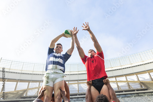 Male rugby players playing rugby match in stadium