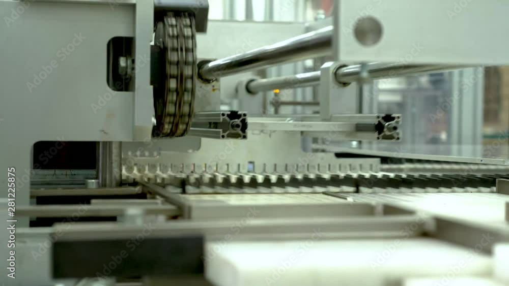Manufacturing machine pushing colored pencils into rows ready for packaging Manufacturing machine pushing colored pencils into rows ready for packaging