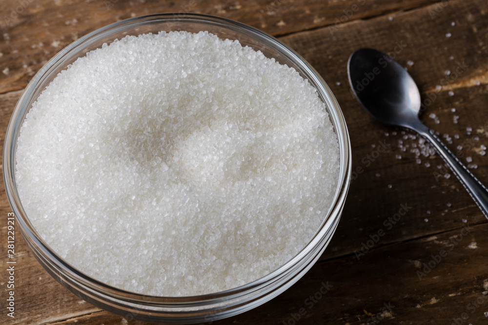 Bowl of sugar with spoon on wooden table Bowl of sugar with spoon on wooden table