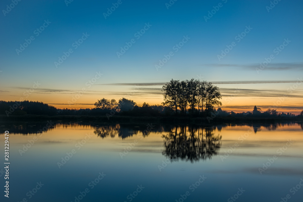 Evening sky and trees reflecting in the water