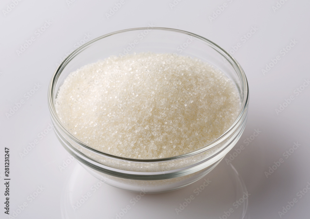 Glass bowl of sugar on white background Glass bowl of sugar on white background