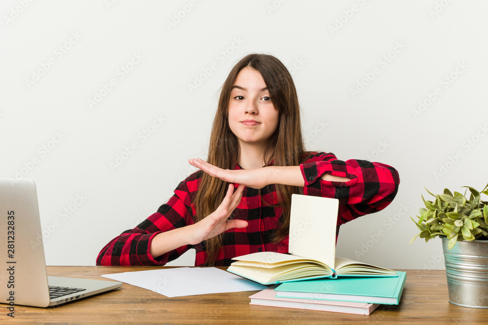 Young teenager going back to her routine doing homeworks showing a timeout gesture. Young teenager going back to her routine doing homeworks showing a timeout gesture.