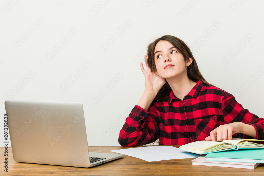 Young teenager going back to her routine doing homeworks trying to listening a gossip. Young teenager going back to her routine doing homeworks trying to listening a gossip.
