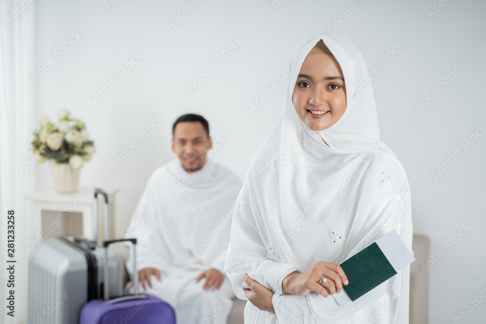 young woman standing in front of her husband wearing white traditional clothes for Ihram ready for Hajj young woman standing in front of her husband wearing white traditional clothes for Ihram ready for Hajj