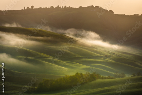 Fantastic sunny spring field in Italy, tuscany landscape morning foggy famous Cypress trees