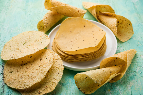 Gujarati papad or papadum in raw dried form with roasted cone, roll and flat variation photo