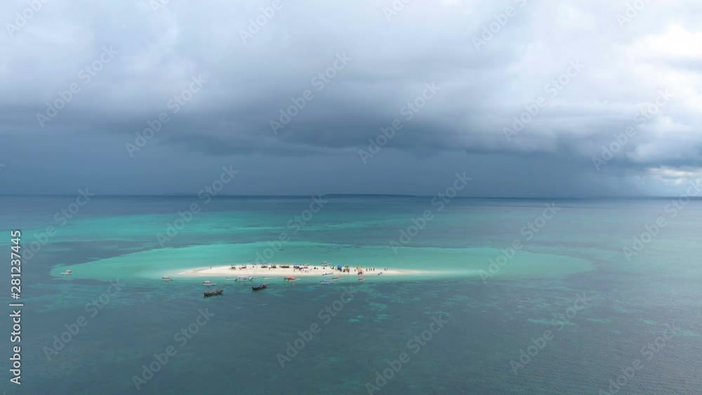 Aerial view of sand tropical island full of people and fishing boats in Africa Aerial view of sand tropical island full of people and fishing boats in Africa