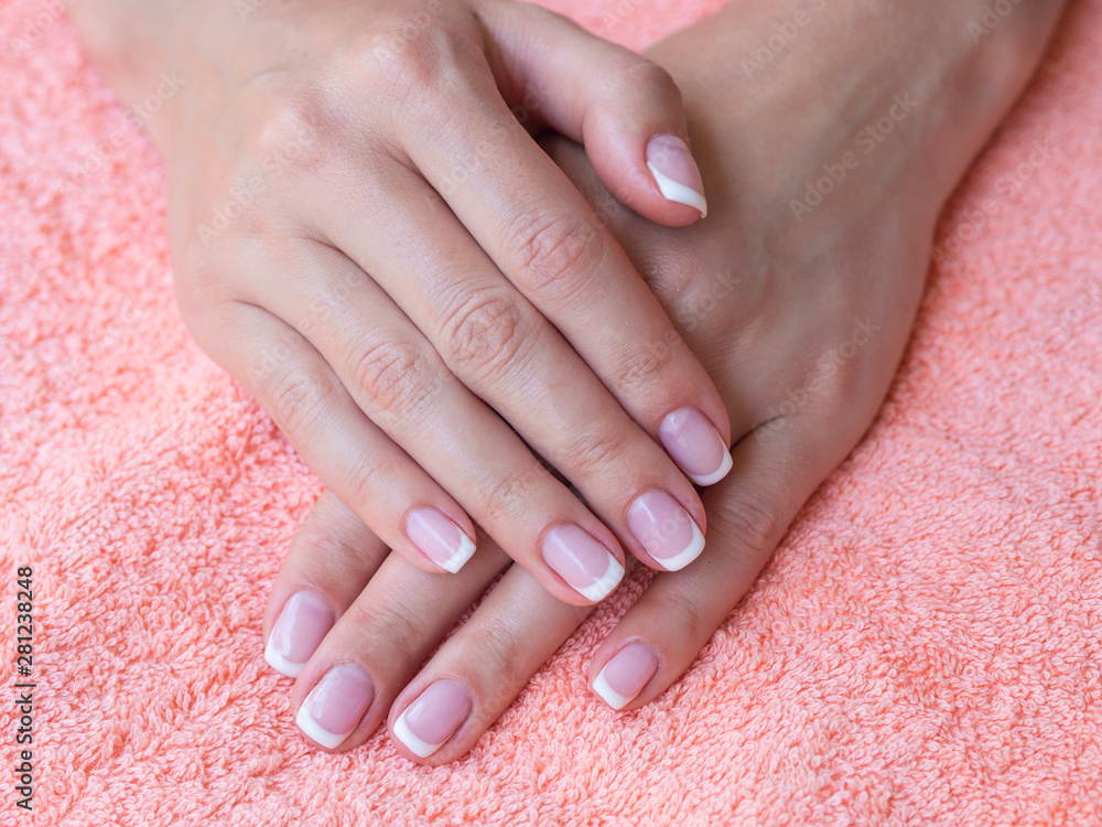 Closeup french manicure in a beauty salon. Woman hand care. Beauty woman nails