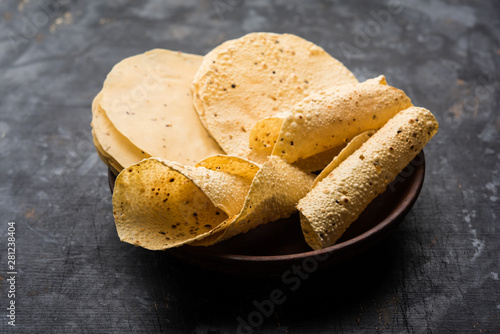 Gujarati papad or papadum in raw dried form with roasted cone, roll and flat variation photo