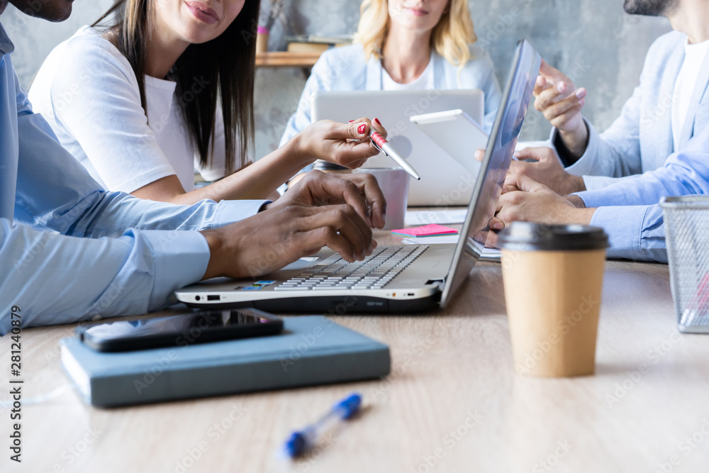 Group of young business people working and communicating while sitting at the office desk together with colleagues sitting in the background. Group of young business people working and communicating while sitting at the office desk together with colleagues sitting in the background.