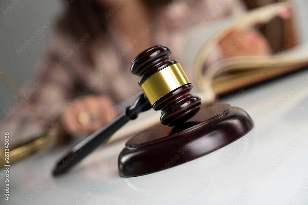 Female attorney in the legal office. Gavel and legal code on the white table. Female attorney in the legal office. Gavel and legal code on the white table.