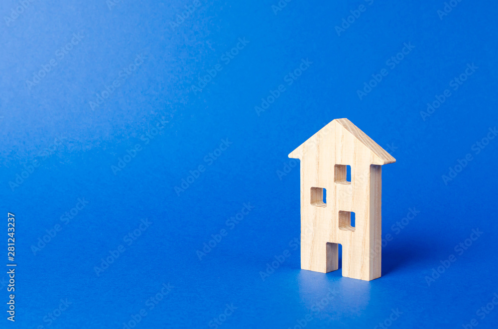A residential building figurine. The concept of buying and selling real estate, renting. Search for a Apartment house. Affordable housing, credit and loans. Urbanism and urbanization. place for text A residential building figurine. The concept of buying and selling real estate, renting. Search for a Apartment house. Affordable housing, credit and loans. Urbanism and urbanization. place for text