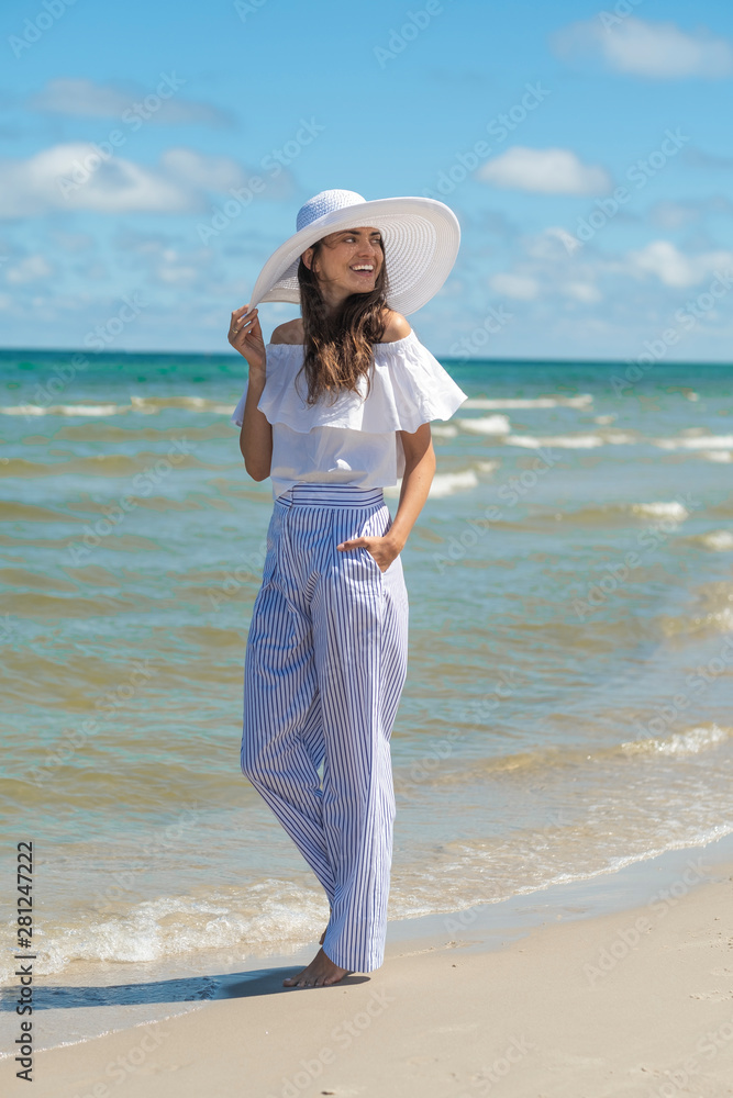 Beautiful woman walking by the seaside.