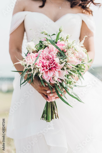Stylish bride with a wedding bouquet in his hands with pink flowers and succulents