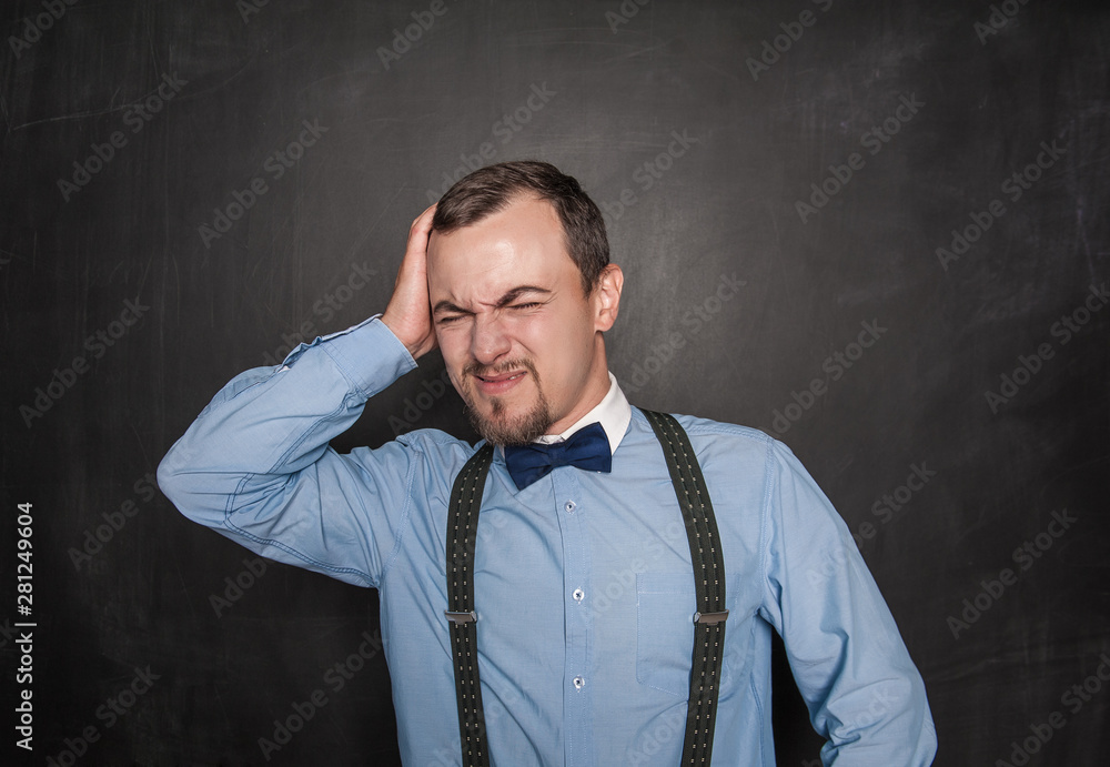 Handsome teacher man with headache on blackboard Handsome teacher man with headache on blackboard