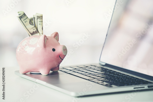 piggy bank with laptop on the desk photo