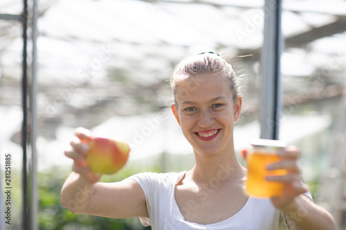 Junge Frau im Garten mit Apfel und Apfelgeleglas