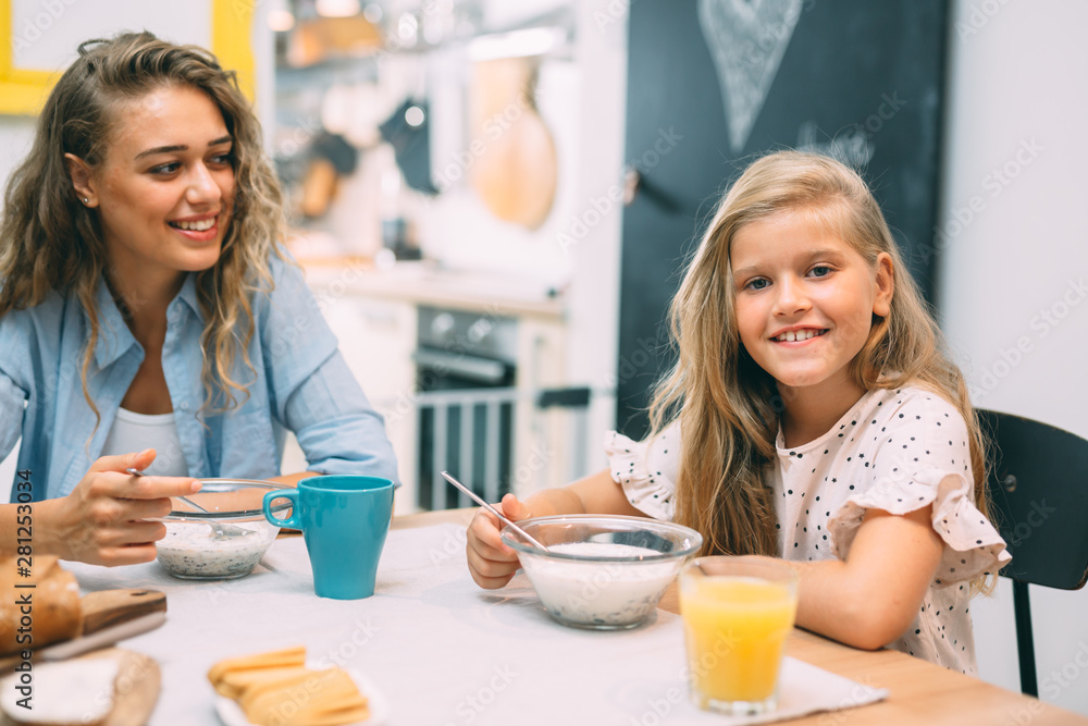 portrait of girl while having breakfast with her mother at home portrait of girl while having breakfast with her mother at home