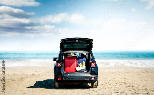 Black summer car on beautiful sunny beach. Summer journey and stopover on the beach.