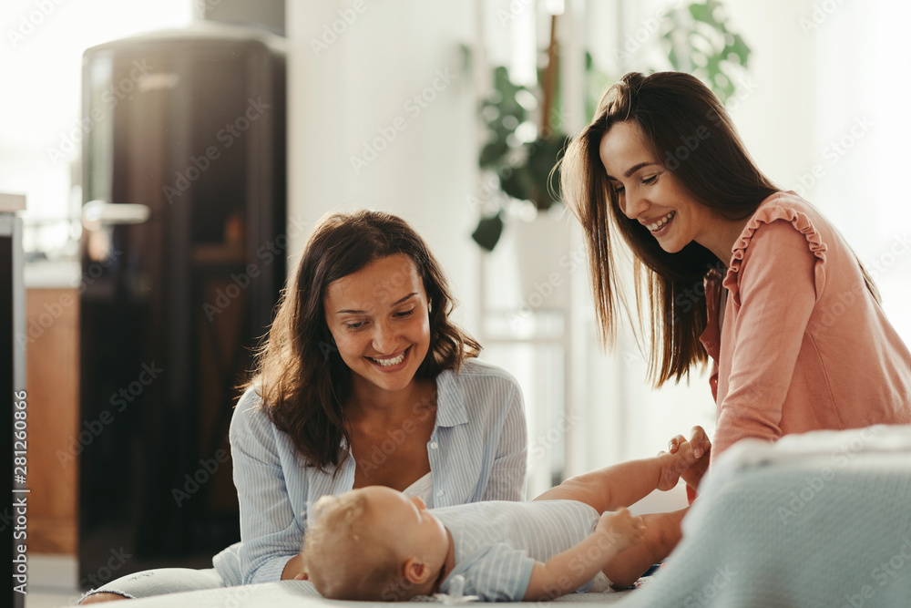 Happy female couple enjoying with their baby boy at home.