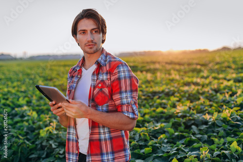 Portrait of agronomist standing in field holding a tablet . -Image