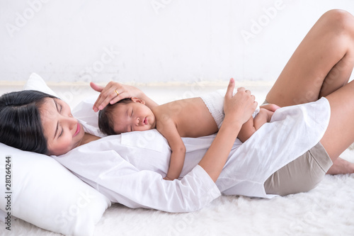Sleeping newborn baby on mother's body.