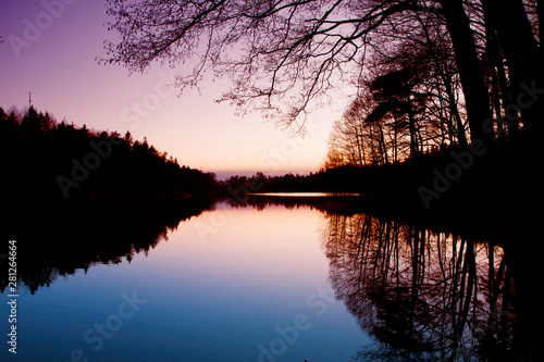 Sweden. Small lake at dusk with trees reflection © acrogame