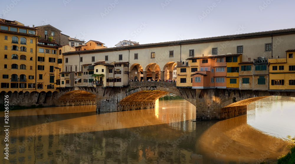 Ponte Vecchio, Florence, Italy on sunset hour, golden river reflect.