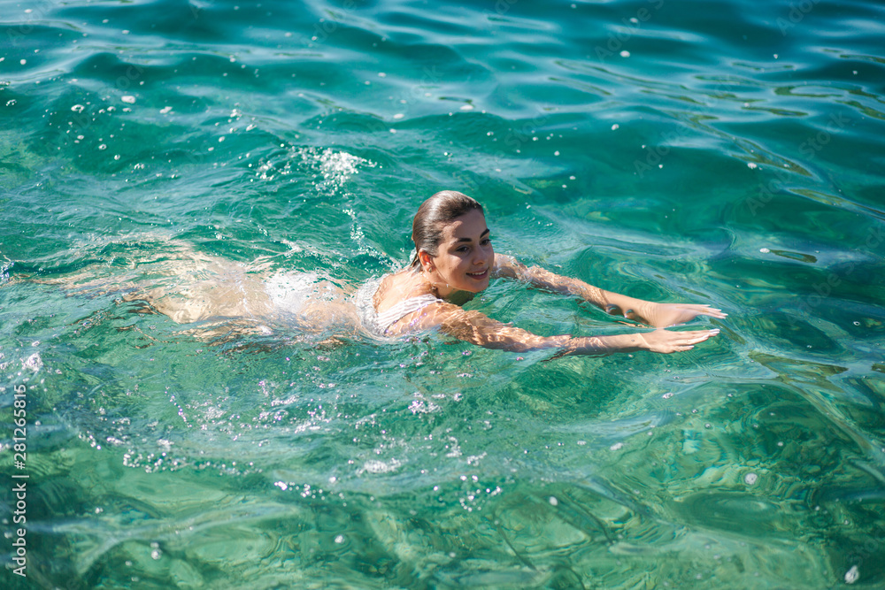 Beautiful woman swimming in the sea. Moring sport