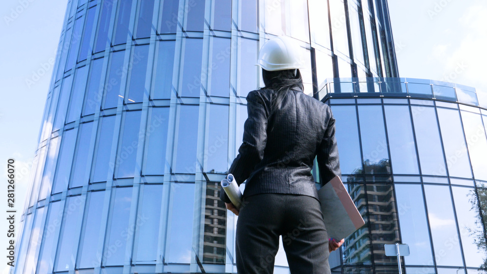 Female contractor in helmet with folder. Building, developing, construction and architecture. Concept of: Woman, Business, Skyscraper, Business plan, Work, Lifestyle, Beautiful. Female contractor in helmet with folder. Building, developing, construction and architecture. Concept of: Woman, Business, Skyscraper, Business plan, Work, Lifestyle, Beautiful.