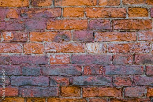 Background of old red brick. The wall of the old house without plaster. Brick is a durable material, but it collapses without a protective layer of plaster. Then the whole wall collapses.