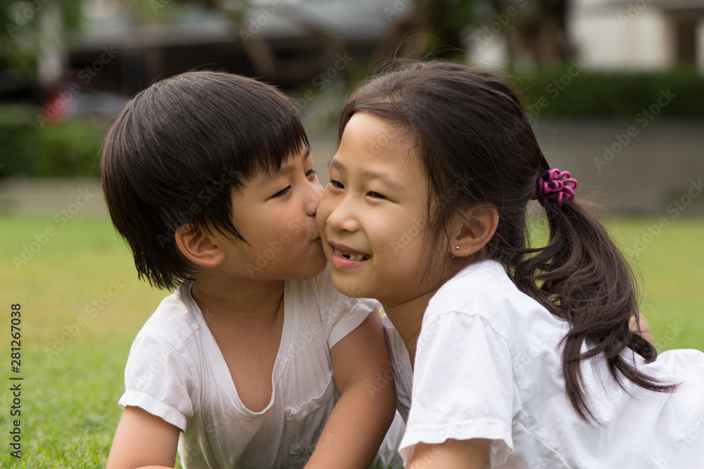 Thai Sister and brother having fun and happiness in a park Thai Sister and brother having fun and happiness in a park