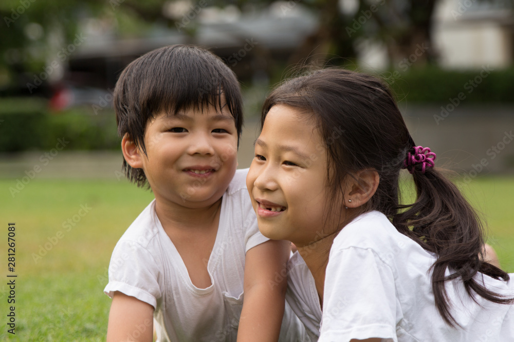 Thai Sister and brother having fun and happiness in a park Thai Sister and brother having fun and happiness in a park