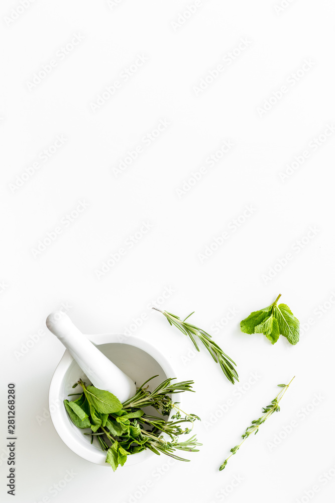 Homeopathy with leaves and healing herbs for making oil on white background top view copyspace