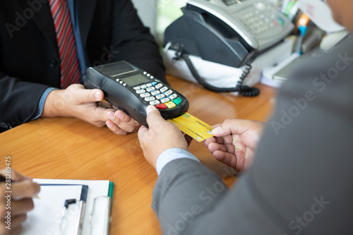 Close up of hands businessman use a credit card swipe to pay for the share transfer fees in the investment of the company.concept of payment