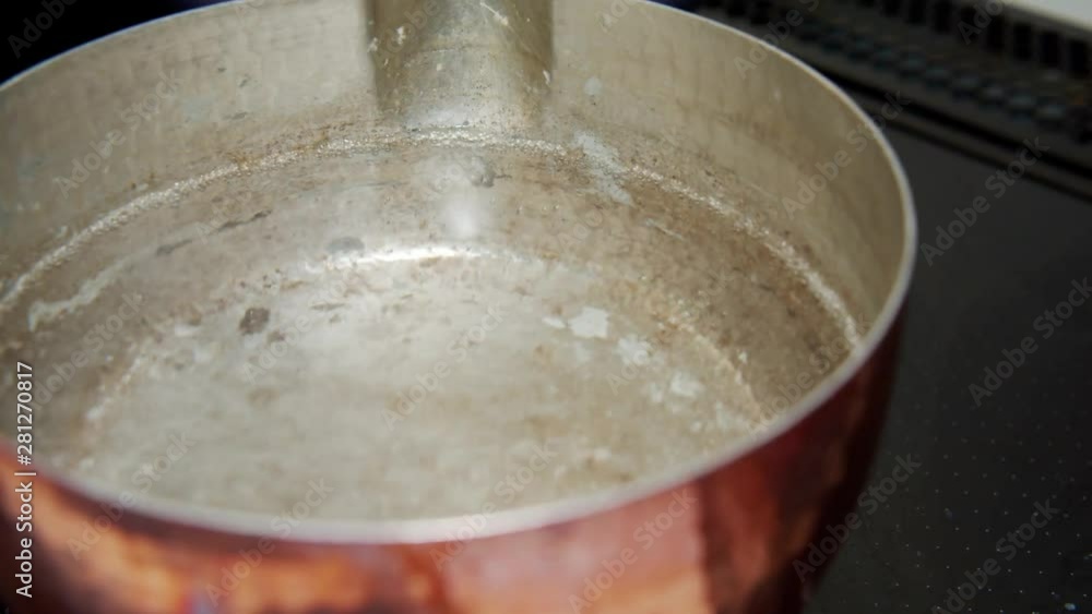 Water started to boil in a copper pan at home kitchen, Tokyo, Japan. May 2019. Camera fixed, extreme close-up, high angle. Water started to boil in a copper pan at home kitchen, Tokyo, Japan. May 2019. Camera fixed, extreme close-up, high angle.